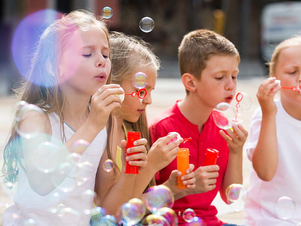 Kids blowing bubbles at school for a birthday treat.