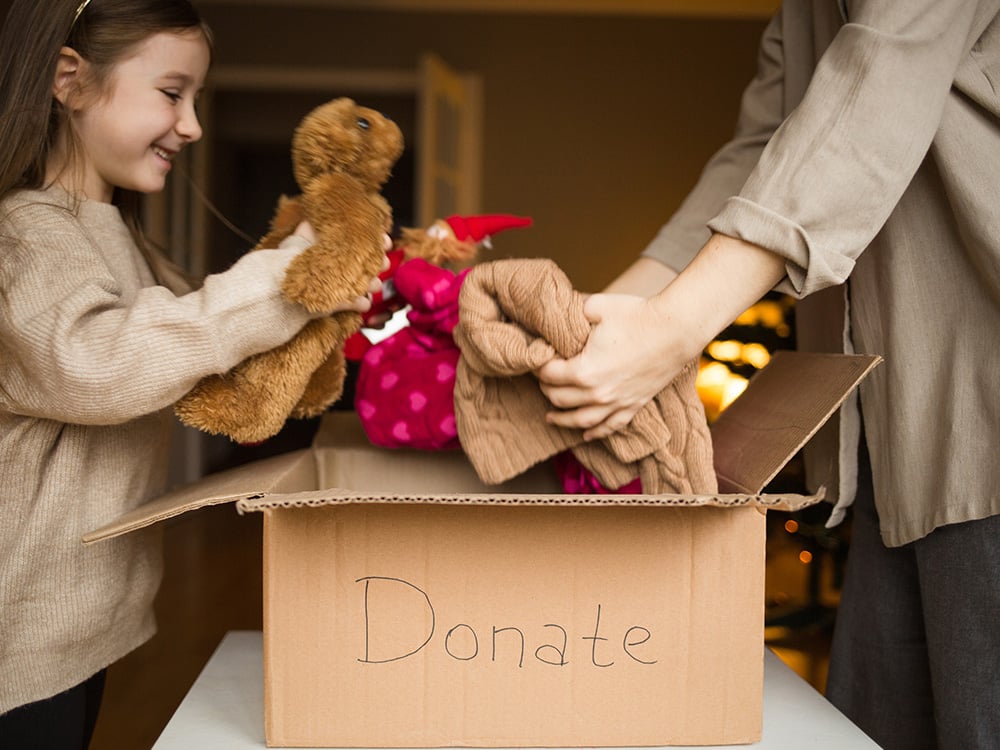 Family putting items in a donation box.